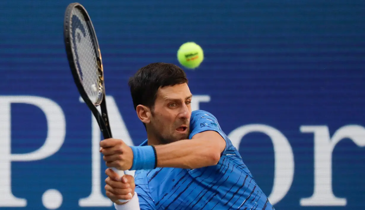 Petenis Serbia, Novak Djokovic  memukul bola ke arah lawannya Roberto Carballes Baena dari Spanyol pada  babak pertama AS Terbuka 2019 di Billie Jean King National Tennis Center, New York, Senin (26/8/2019). Peringkat satu dunia itu menang 6-4, 6-1, dan 6-4. (AP/Frank Franklin II)