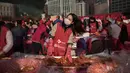 Seorang peserta membuat kimchi, hidangan tradisional Korea Selatan, selama Festival Kimchi tahunan di pusat kota Seoul, Jumat (3/11). Kimchi merupakan makanan yang terbuat dari sawi putih atau lobak yang difermentasikan. (Ed JONES/AFP)