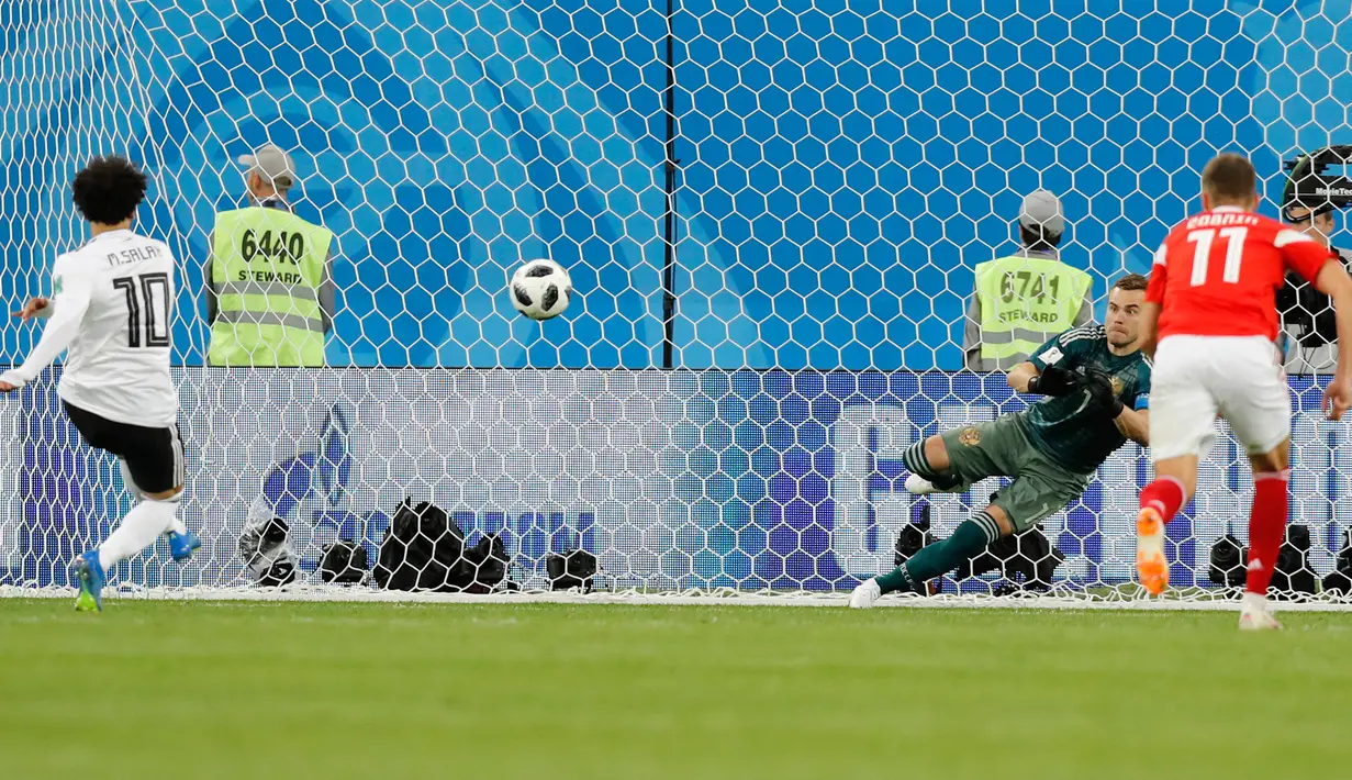 Penyerang Mesir, Mohamed Salah saat melakukan tendangan penalti melawan Rusia pada grup A Piala Dunia 2018 di stadion St. Petersburg di St. Petersburg, (19/6). Rusia menang 3-1 atas Mesir. (AP Photo / Efrem Lukatsky)