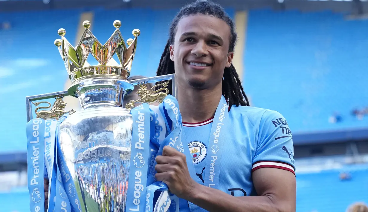 Bek Manchester City, Manuel Akanji berpose dengan trofi Liga Inggris saat perayaan gelar usai laga pekan ke-37 menghadapi Chelsea di Etihad Stadium, Manchester (21/5/2023). Manuel Akanji didatangkan pada awal musim 2022/2023 dari Borussia Dortmund. Sejauh ini ia telah tampil 29 kali di Liga Inggris, termasuk di laga terakhir saat menang 1-0 atas Chelsea, dengan torehan 1 assist. (AP Photo/Jon Super)