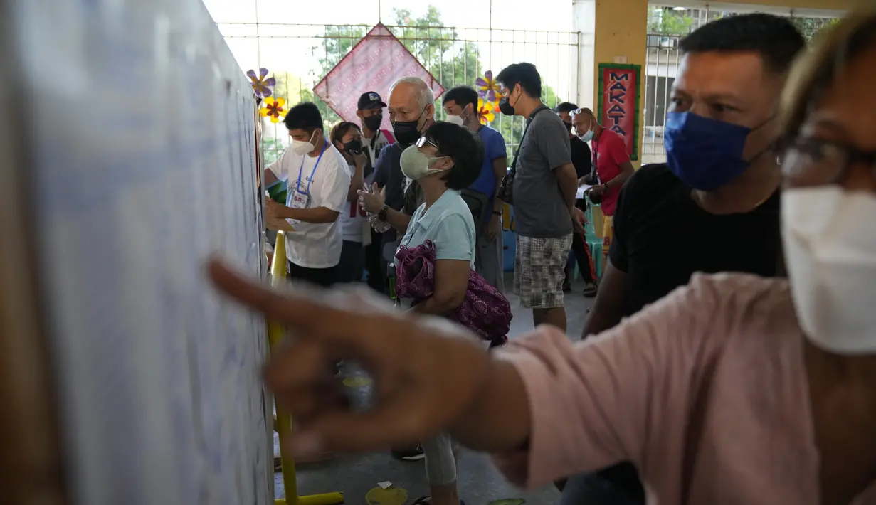 <p>Warga mencari daerah pemilihannya dalam daftar yang dipasang di tempat pemungutan suara di Manila, Filipina, Senin (9/5/2022). Warga Filipina mulai memberikan suara untuk memilih presiden baru pada hari Senin, dengan putra mantan diktator yang digulingkan menjadi pesaing terkuat seorang pejuang reformasi dan hak asasi manusia. (AP Photo/Aaron Favila)</p>