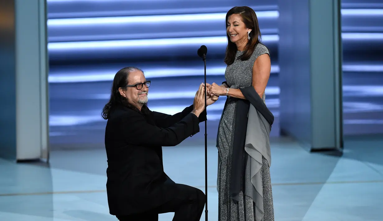 Sutradara Glenn Weiss melamar kekasihnya, Jan Svendsen saat menerima penghargaan di atas panggung Emmy Awards 2018, Los Angeles, Selasa (18/9). Weiss mendapat penghargaan untuk Outstanding Directing for a Variety Special Emmy. (Chris Pizzello/Invision/AP)