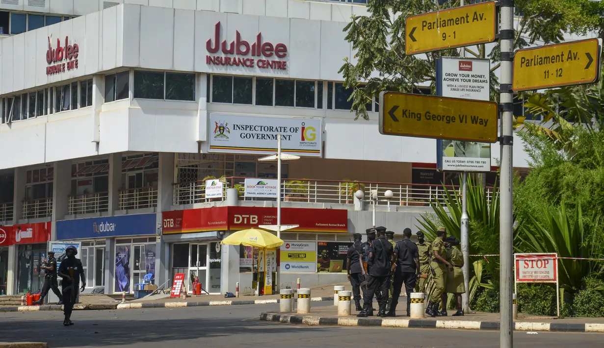 Pasukan keamanan mengamankan lokasi ledakan di sebuah jalan dekat gedung parlemen di Kampala, Uganda (16/11/2021).  Serangan yang terjadi di dekat parlemen Uganda dan markas polisi terjadi hampir bersamaan dengan selisi kurang dari tiga menit. (AP Photo/Ronald Kabuubi)