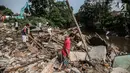 Sejumlah warga mengumpulkan kayu bekas sisa penertiban bangunan di bantaran Sungai Ciliwung, kawasan Bukit Duri, Jakarta Selatan, Selasa (11/7). Terdapat 355 bangunan yang ditertibkan guna menanggulangi banjir di Jakarta ini (Liputan6.com/Faizal Fanani)