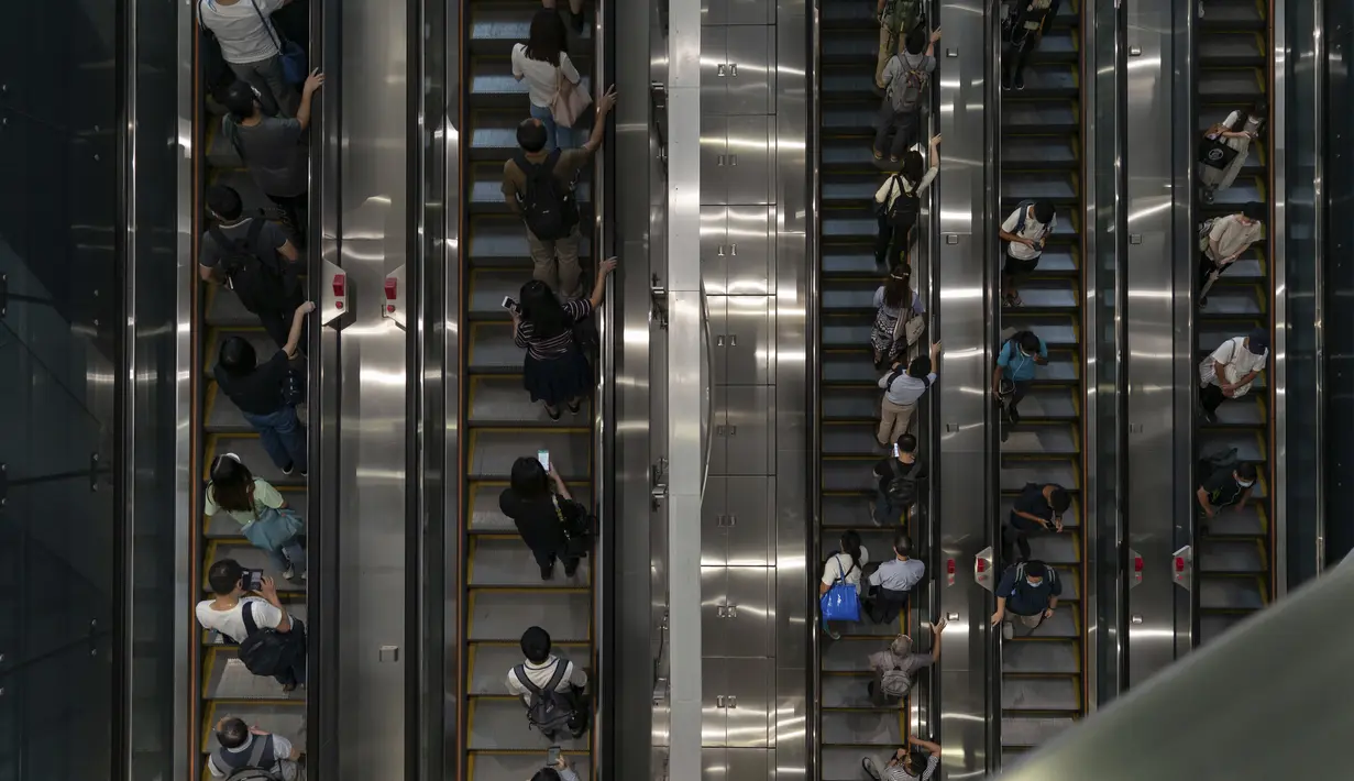 Orang-orang menaiki eskalator di stasiun MTR Admiralty saat badai tropis Ma-on melewati Hong Kong, Kamis (25/8/2022). Badai Tropis Ma-on semakin kuat saat menuju Hong Kong dan bagian tenggara lainnya China pada hari Rabu setelah menggusur ribuan orang di Filipina. (AP Photo/Anthony Kwan)