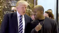 Presiden AS terpilih, Donald Trump dan Kanye West bebrincang sambil berjalan di lobi Trump Tower, New York, Selasa (13/12). Trump dan Kanye West melakukan pertemuan tertutup untuk membahas masalah multikultural. (TIMOTHY A. CLARY/AFP)