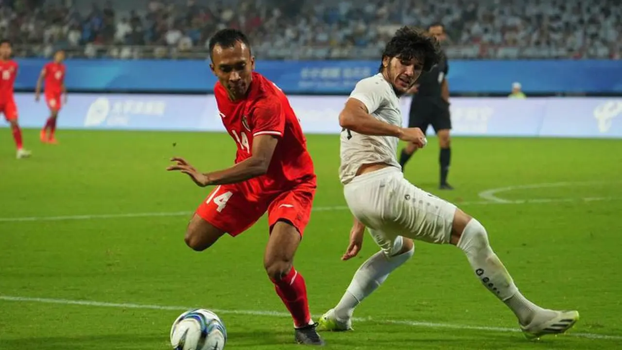 Aksi Robi Darwis (kiri) di laga 16 besar Asian Games 2023 antara Uzbekistan vs Indonesia U-24 di Shangcheng Sports Centre Stadium, Hangzhou, Kamis (28/09/2023). (c) NOC Indonesia/Naif Al-As