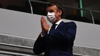 Presiden Prancis Emmanuel Macron menyapa orang-orang menjelang upacara pembukaan Olimpiade Tokyo 2020, di Olympic Stadium di Tokyo, Jumat (23/7/2021). Upacara pembukaan Olimpiade Tokyo yang berlangsung dalam era pandemi digelar tanpa penonton. (Dylan MARTINEZ / POOL / AFP)