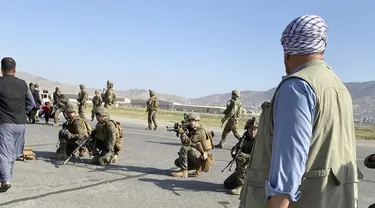 Tentara AS mengambil posisi untuk menjaga di sepanjang perimeter di bandara internasional di Kabul, Afghanistan (16/8/2021). Militer dan pejabat AS fokus di bandara Kabul, di mana ribuan warga Afghanistan terjebak oleh Taliban tiba-tiba. (AP Photo/Shekib Rahmani)