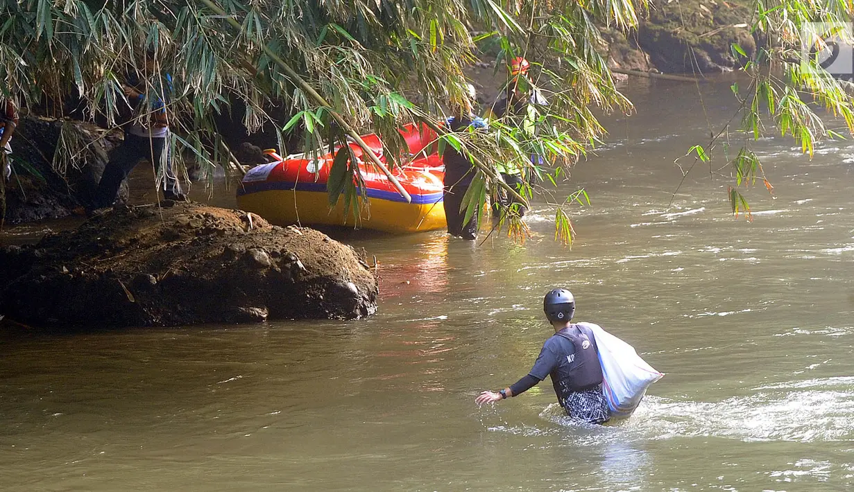 Sukarelawan membawa karung saat memunguti sampah di aliran sungai saat kegiatan Bebersih Ciliwung di Yayasan Bambu Indonesia, Cibinong, Bogor, Jawa Barat, Minggu (23/6/2019). Sebanyak 8.000 peserta mengikuti kegiatan Bebersih Ciliwung. (merdeka.com/Arie Basuki)
