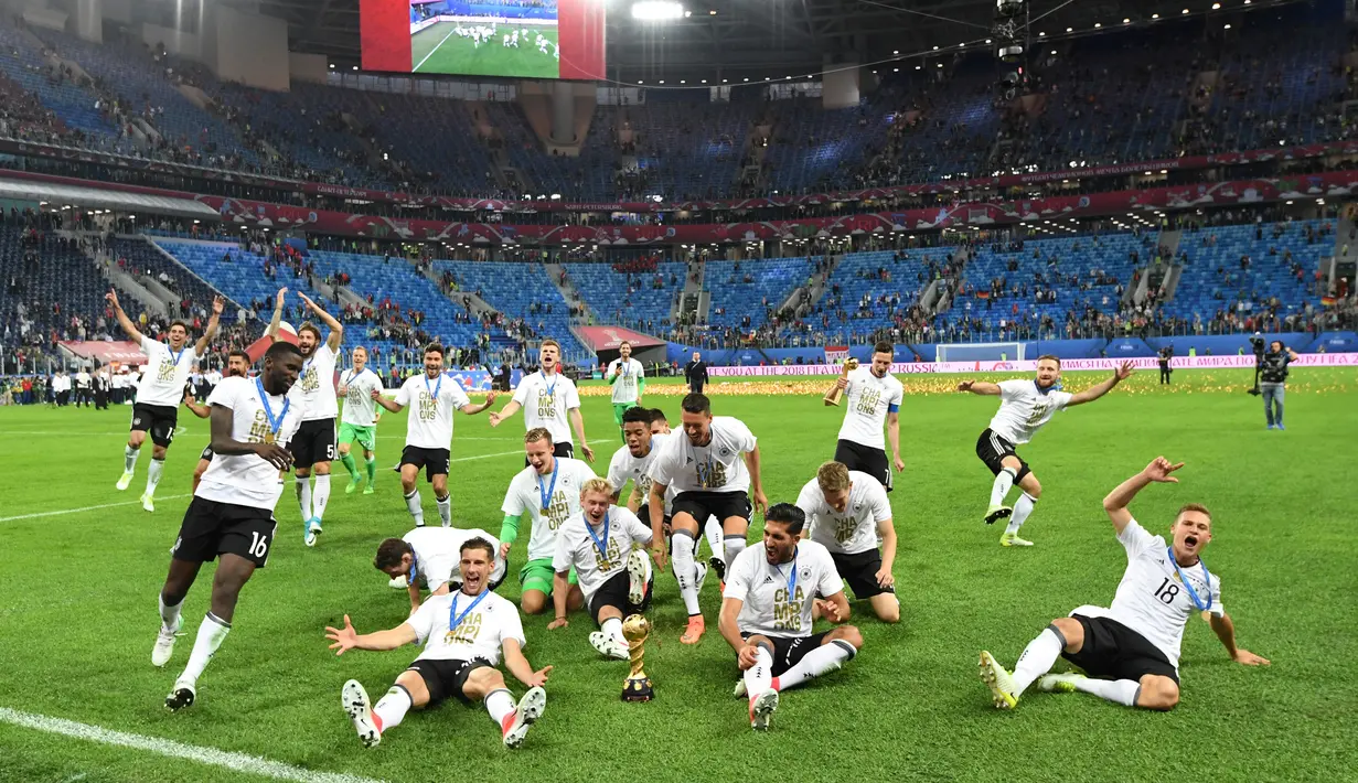 Pemain Jerman berlari menuju piala saat merayakan kemenangannya dalam final Piala Konfederasi 2017 di Stadion Saint Petersburg, Rusia (2/7). Gol tunggal tersebut berhasil dicetak oleh pemain Jerman, Lars Stindl. (AFP Photo/Kirill Kudryavtsev)
