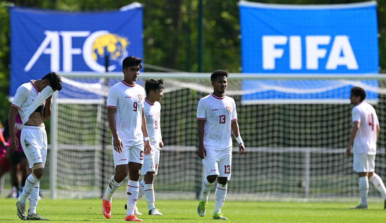 Para pemain timnas Indonesia U-23 meninggalkan lapangan usai dikalahkan pada pertandingan play-off pra-Olimpiade 2024 melawan Guinea di Clairefontaine-en-Yvelines, Paris, pada 9 Mei 2024. (MIGUEL MEDINA/AFP)