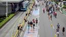 Sejumlah orang yang mengenakan batik berjalan di catwalk sepanjang Jalan Jenderal Sudirman, Jakarta, Minggu (2/10/2022). Kegiatan yang diikuti ratusan orang ini diselenggarakan oleh Bank Mandiri untuk menyambut Hari Batik Nasional yang jatuh setiap tanggal 2 Oktober 2022. (Liputan6.com/Faizal Fanani)