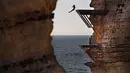 Peserta melompat dari batu karang laut 'Raouche' yang terkenal dalam kompetisi Red Bull Cliff Diving World Series di Beirut, Lebanon, 14 Juli 2019. Sebanyak 40 atlet terdiri dari 10 wanita dan 14 pria yang berasal dari 18 negara melakukan lompatan dari ketinggian 21 - 27 meter. (AP/Hussein Malla)