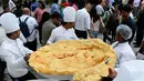 Roti goreng Bhatura dengan diameter 147 cm telah selesai dibuat, India, New Delhi, Kamis (6/4). Penyelenggara berharap Bhatura buatan mereka bisa memecahkan rekor Bhatura  terbesar di India. (AFP PHOTO / SAJJAD HUSSAIN)