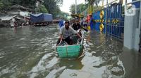 Warga menaiki sampan untuk melewati banjir rob di kawasan Pelabuhan Sunda Kelapa, Jakarta, Selasa (7/12/2021). Banjir rob setinggi satu meter memutus Jalan Kerapu yang menghubungkan Ancol-Pluit. (merdeka.com/Arie Basuki)