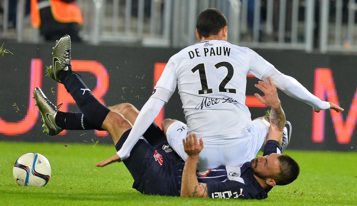 Pemain Guingamp, Nill de Pauw (atas), terjatuh di atas tubuh pemain Bordeaux, Diego Contento, dalam laga Liga Prancis di Stadion Matmut Atlantique,Bordeaux, Prancis, (6/12/2015). (AFP/Nicolas Tucat)