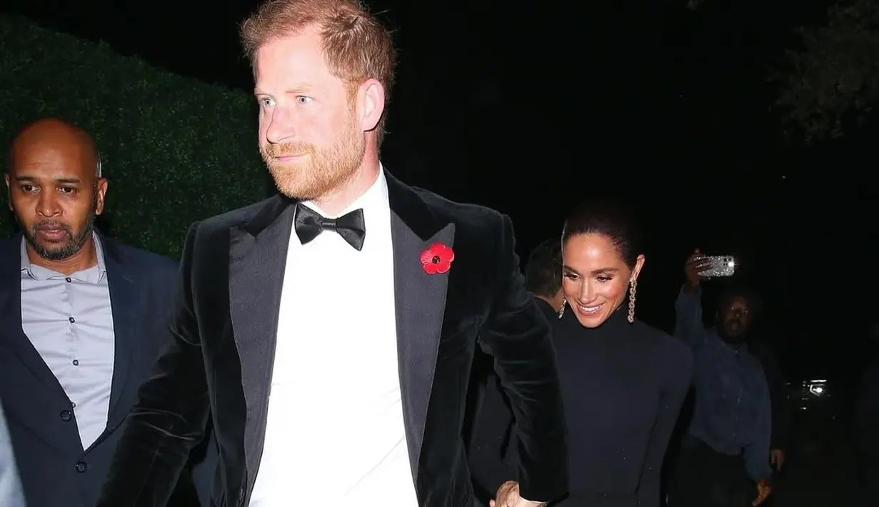 Pasangan Pangeran Harry dan Meghan Markle membuat kejutan dengan hadir setelah menghadiri acara Baby2Baby gala di malam yang sama. Harry tampil rapi dengan jas hitam berhias pin poppy merah sebagai simbol peringatan Remembrance Day. [@deuxmoi].