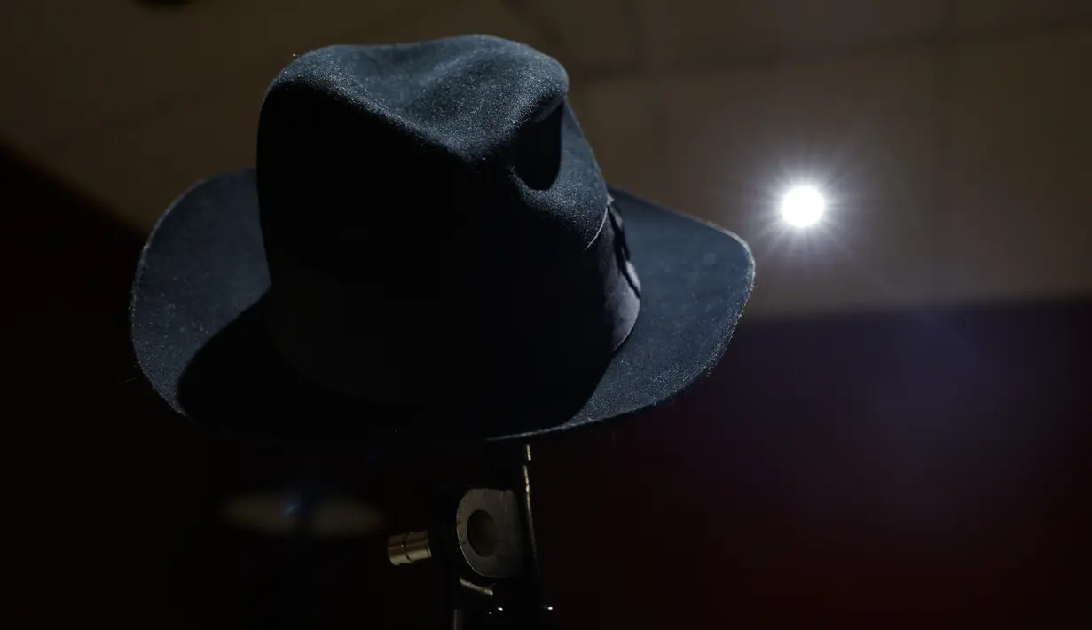 Setelah melepas topinya, Jackson memamerkan gerakan ikoniknya, moonwalk, yang merupakan gerakan meluncur mundur tanpa susah payah sambil tetap terlihat berjalan ke depan. (Geoffroy VAN DER HASSELT / AFP)