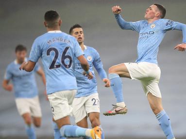 Gelandang Manchester City, Phil Foden (kanan) melakukan selebrasi usai mencetak gol ke gawang Brighton and Hove Albion dalam laga lanjutan Liga Inggris 2020/21 di Etihad Stadium, Rabu (13/1/2021). Manchester City menang 1-0 atas Brighton. (AFP/Clive Brunskill/Pool)