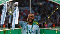 Gelandang Manchester City, Raheem Sterling mengangkat trofi setelah memenangkan pertandingan final Piala Liga Inggris melawan Chelsea di stadion Wembley, London, Minggu (24/2). Manchester City Chelsea lewat drama adu penalti 4-3. (Adrian DENNIS / AFP)