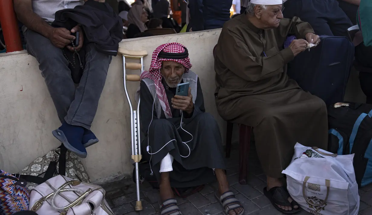 Warga Palestina menunggu untuk menyeberang ke Mesir di perbatasan Rafah di Jalur Gaza, pada Senin, 16 Oktober 2023. (AP Photo/Fatima Shbair)