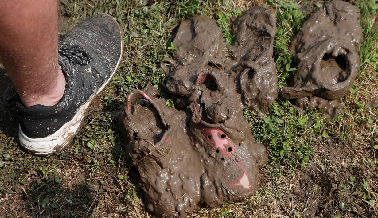 Sepatu tertutup lumpur terlihat saat Mud Day atau Hari Lumpur di Michigan, negara bagian AS, Selasa (9/7/2019). Para peserta perayaan yang menjadi tradisi setiap tahun ini merupakan anak-anak untuk agar mereka bersenang-senang selama liburan musim panas.  (AP/Carlos Osorio)