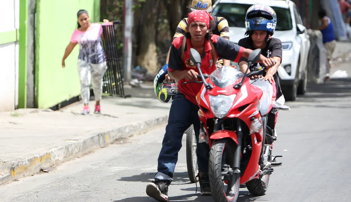 Penjarah membawa sepeda motor yang baru saja mereka jarah dari sebuah toko di Managua, Nikaragua, Minggu (22/4). Puluhan toko di Ibu Kota telah dijarah dalam protes antipemerintah di Nikaragua. (AP Photo/Alfredo Zuniga)