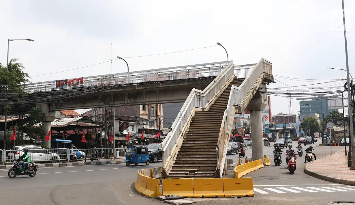 Suasana JPO di Jalan Dewi Sartika, Cawang, Jakarta Timur, berada di tengah jalan, Rabu (9/1). Adanya proyek pelebaran jalan menyebabkan posisi trotoar bergeser sehingga tangga JPO tersebut menjadi di tengah jalan. (Liputan6.com/Immanuel Antonius)