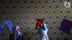 Warga menempelkan kain tenun motif Betawi di Rusunawa Jatinegara, Jakarta, Rabu (13/11/2019). Pemerintah akan memprioritaskan penyaluran  Kredit Usaha Rakyat (KUR) kelompok, seiring dengan diturunkannya suku bunga KUR per 1 Januari 2020 menjadi 6 persen, dari  7 persen. (Liputan6.com/Angga Yuniar)