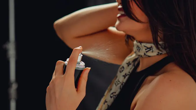Wanita menyemprotkan parfum