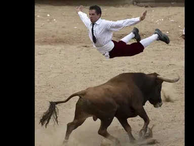  Seorang matador melompat di atas banteng di arena adu banteng Canaveralejo di Cali, Kolombia, Senin (21/12/2014). (AFP Photo/Luis Robayo)