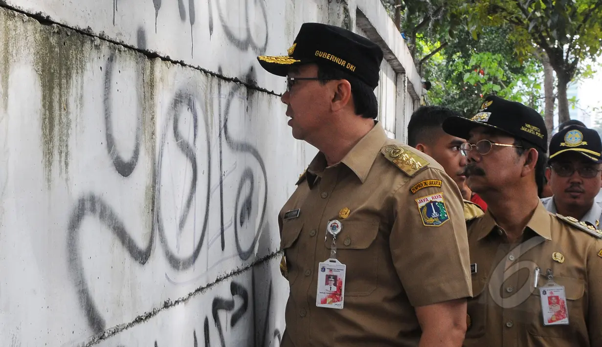 Gubernur DKI Jakarta Basuki T Purnama melihat kondisi tembok di sekitar kawasan pasar Tanah Abang, Jakarta, Rabu (15/4). Ahok berjalan kaki dari Stasiun Tanah Abang menuju Pasar Blok G untuk mengecek kondisi trotoar jalan. (Liputan6.com/Herman Zakharia)