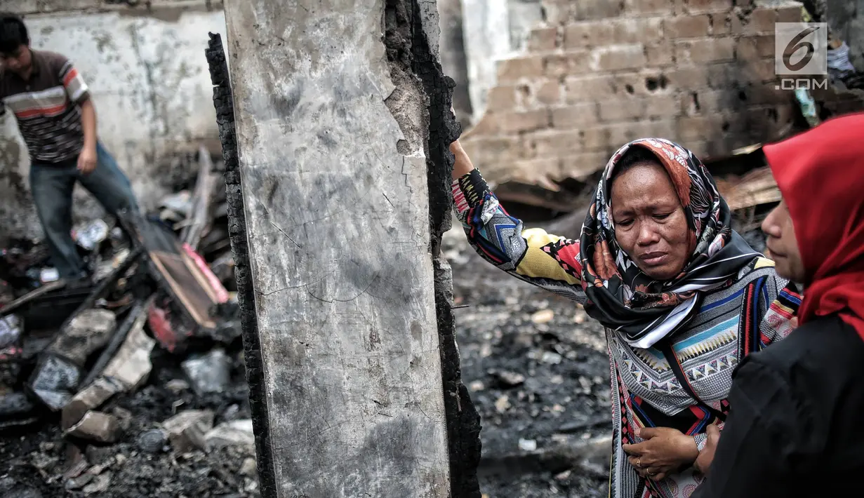 Warga menangis saat mengunjungi lokasi kebakaran yang menghanguskan Kelurahan Kebon Kosong, Kemayoran, Jakarta, Rabu (26/12). Warga Kelurahan Kebon Kosong yang rumahnya dilanda kebakaran kini mengungsi. (Liputan6.com/Faizal Fanani)