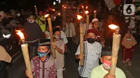 Sejumlah warga saat melakukan pawai obor di Kawasan Rempoa, Tangerang Selatan, Rabu (19/08/2020). Pawai obor tersebut dilakukan dalam rangka menyambut peringatan tahun baru Islam 1 Muharram 1442 H. (Liputan6.com/Herman Zakharia)