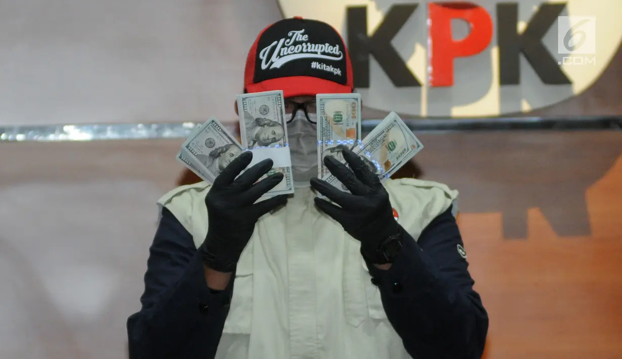 Petugas menunjukkan barang bukti uang sebesar USD 30 ribu hasil OTT kasus dugaan suap kuota impor ikan di Gedung KPK, Jakarta, Selasa (24/09/2019). KPK menetapkan dua tersangka terkait kuota impor jenis ikan frozen pacific mackerel atau ikan salem. (merdeka.com/Dwi Narwoko)