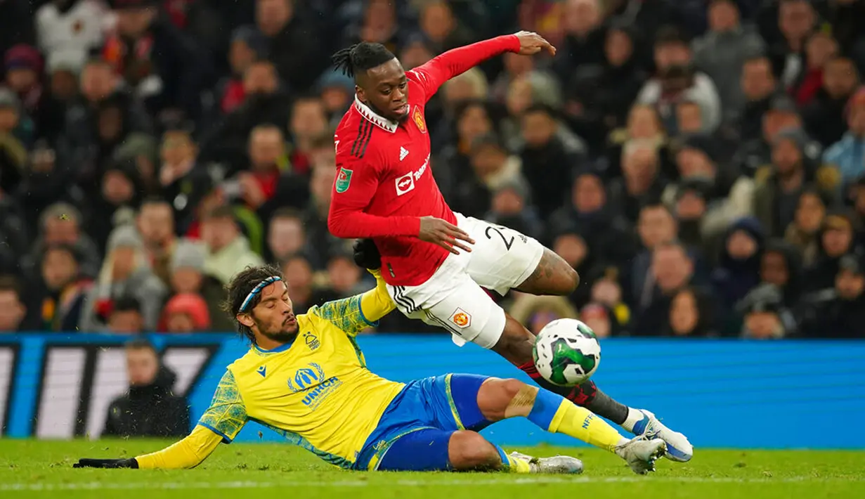 Pemain Nottingham Forest Gustavo Scarpa berebut bola dengan pemain Manchester United Aaron Wan-Bissaka (atas) pada pertandingan sepak bola leg kedua semifinal Piala Liga Inggris di Old Trafford, Manchester, Inggris, 1 Februari 2023. Manchester United melaju ke final Piala Liga Inggris usai mengalahkan Nottingham Forest dengan skor 3-0 pada leg pertama dan 2-0 pada leg kedua. (AP Photo/Dave Thompson)