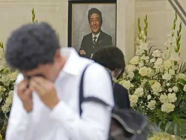 Reaksi seorang pria setelah memberi bunga dan doa untuk mantan Perdana Menteri Jepang Shinzo Abe di kuil Zojoji, Tokyo, Sabtu (8/7/2023). (AP Photo/Shuji Kajiyama)