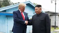 Presiden AS, Donald Trump bertemu dengan Pemimpin Korea Utara, Kim Jong-un di zona demiliterisasi Korea (DMZ), Desa Panmunjom pada Minggu (30/6/2019).  Pertemuan keduanya berawal ketika Trump menuliskan undangan pertemuan dengan Kim melalui Twitter. (AP Photo/Susan Walsh)