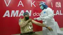 Vaksinator menyuntikkan vaksin COVID-19 kepada guru di SMA 70, Jakarta, Rabu (25/2/2021). Sebanyak 600 orang dari profesi guru, tenaga kependidikan, dan dosen akan divaksin COVID-19 hari ini. (Liputan6.com/Faizal Fanani)
