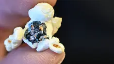 Popcorn bergambar dua pria bersenjata berpakaian hitam karya seniman mikro Hasan Kale, Istanbul, Turki, 23 Agustus 2019. Seniman mikro Turki menjadikan popcorn hingga lipstik sebagai kanvas lukis yang menakjubkan. (OZAN KOSE/AFP)