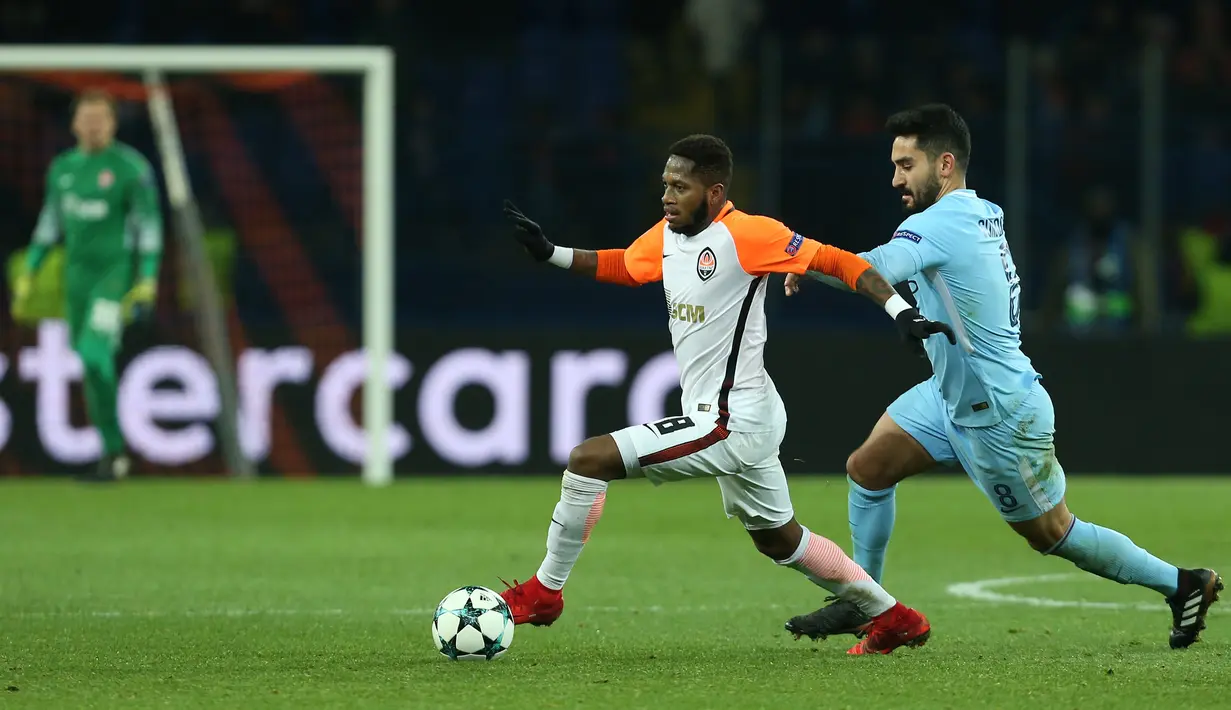 Pemain Manchester City, Ilkay Gundoganberusaha merebut bola dari pemain Shakhtar Donetsk, Fred pada matchday terakhir Grup F Liga Champions di Stadion Oblasny Sport Komplex Metalist, Kamis (7/12). Manchester City takluk 1-2. (Stanislas VEDMID / AFP)