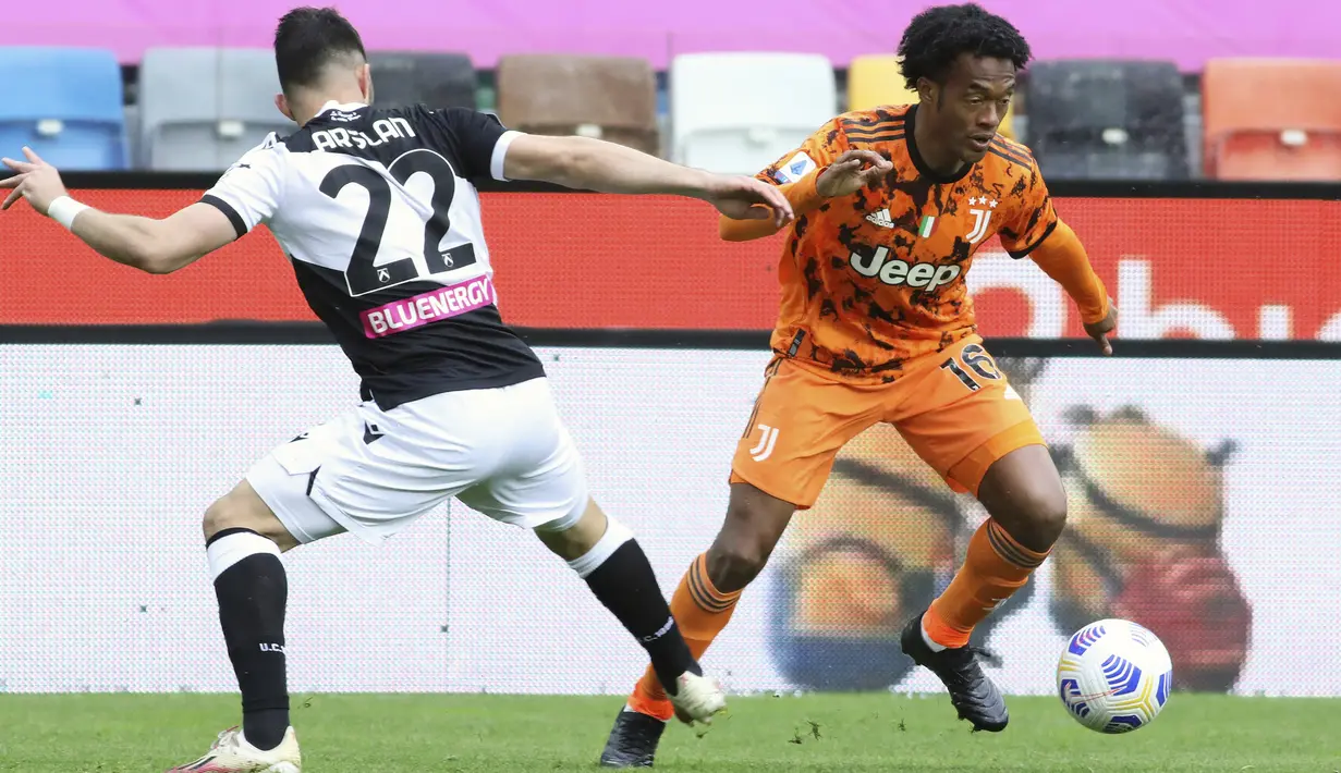 Gelandang Juventus, Juan Cuadrado berusaha melewati pemain Udinese, Tolgay Arslan pada pertandingan Liga Italia di di stadion Dacia Arena di Udine, Italia, Senin (3/5/2021). Tambahan tiga poin membuat Juventus naik ke posisi tiga klasemen dengan 69 poin. (Andrea Bressanutti/LaPresse via AP)