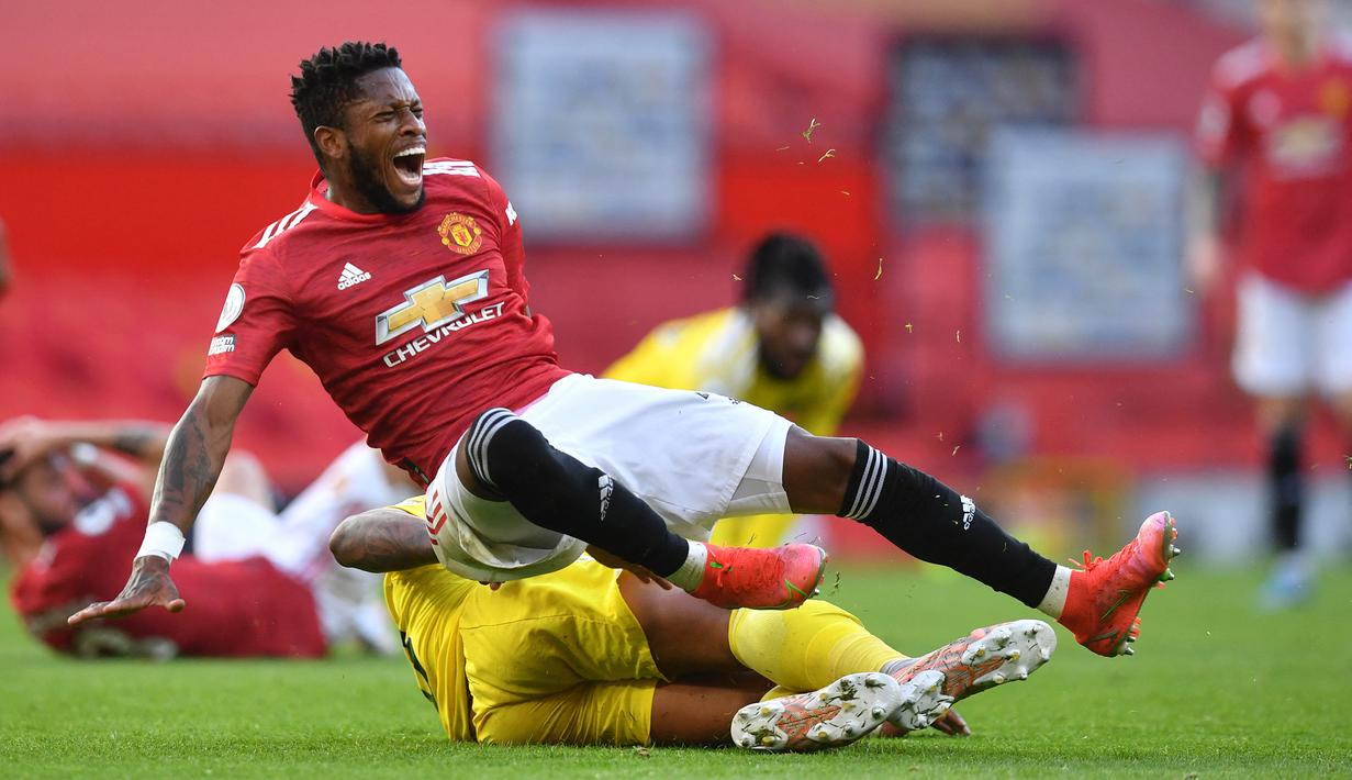 Gelandang Manchester United, Fred (depan) terjatuh usai ditekel gelandang Fulham, Mario Lemina dalam laga lanjutan Liga Inggris 2020/2021 pekan ke-37 di Old Trafford Stadium, Rabu (18/5/2021). Manchester United bermain imbang 1-1 dengan Fulham. (AFP/Paul Ellis/Pool)