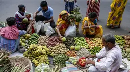 Pelanggan membeli buah-buahan di pinggir jalan menjelang festival Hindu Chhath, di Kolkata, India (9/11/2021). Selama Chhath, festival Hindu kuno yang populer di kalangan kelas pekerja, ritual dilakukan untuk berterima kasih kepada Dewa Matahari atas menopang kehidupan di bumi. (AP Photo/Bikas Das)