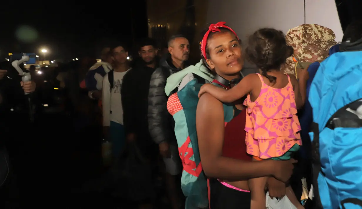 Para migran Venezuela menaiki bus yang akan membawa mereka ke tempat penampungan di kota Arica, Chile, Jumat (5/5/2023). (Photo by AGUSTIN MERCADO / AFP)