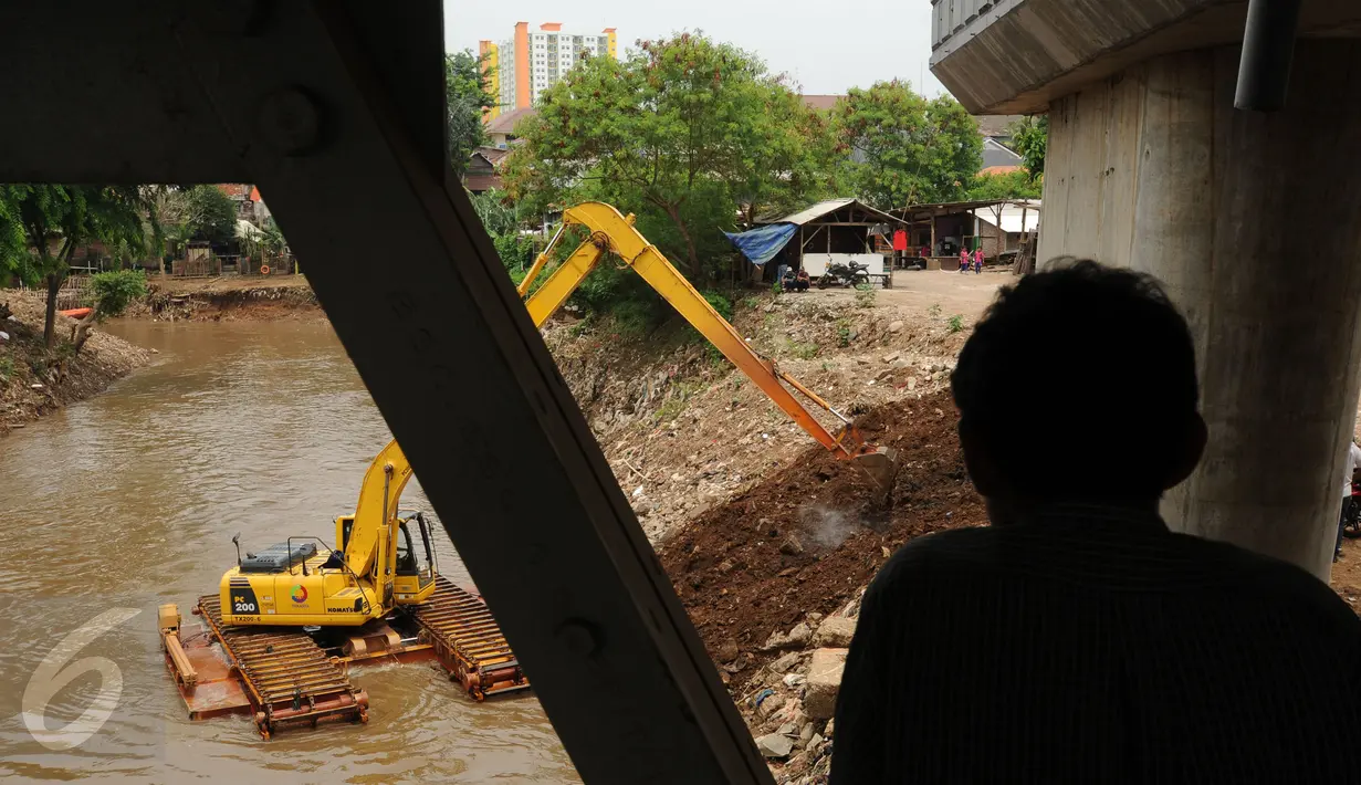 Warga menonton pengerukan sungai Ciliwung di kolong jalan layang Kalibata Jakarta, Kamis (19/11/2015). Pemprov DKI Jakarta segera melakukan pembongkaran jembatan Kalibata untuk mengatasi banjir akibat penumpukan sampah. (Liputan6.com/Helmi Fithriansyah)