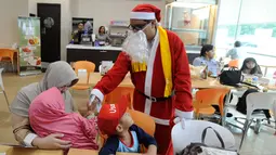 Santa Claus membagikan bingkisan Natal kepada pasien anak yang dirawat di RS Siloam, TB Simatupang, Jakarta, Kamis (21/12). Kegiatan ini dalam rangka menyambut perayaan Hari Natal 2017. (Liputan6.com/Joan)