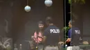 Anggota Reskrim Polda Metro Jaya berbincang dengan seorang wanita saat pra-rekonstruksi di Cafe Olivier, Mal Grand Indonesia, Jakarta, Senin (11/1). Wayan Mirna Salihin meninggal setelah minum kopi di kafe tersebut. (Liputan6.com/Faizal Fanani)