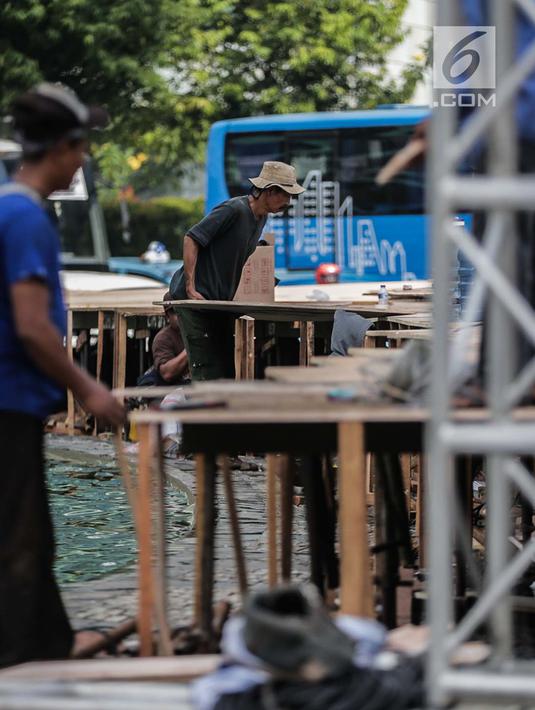 Pekerja menyelesaikan pembuatan panggung HUT ke-492 DKI di area Bundaran HI, Jakarta, Kamis (20/6/2019). Panggung megah tersebut nantinya akan digunakan sebagai area pesta rakyat. (Liputan6.com/Faizal Fanani)